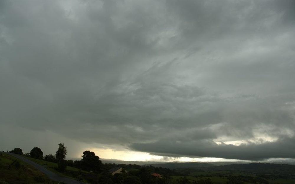 Nuages nimbostratus formant une couverture nuageuse épaisse et basse, accompagnée de précipitations continues.